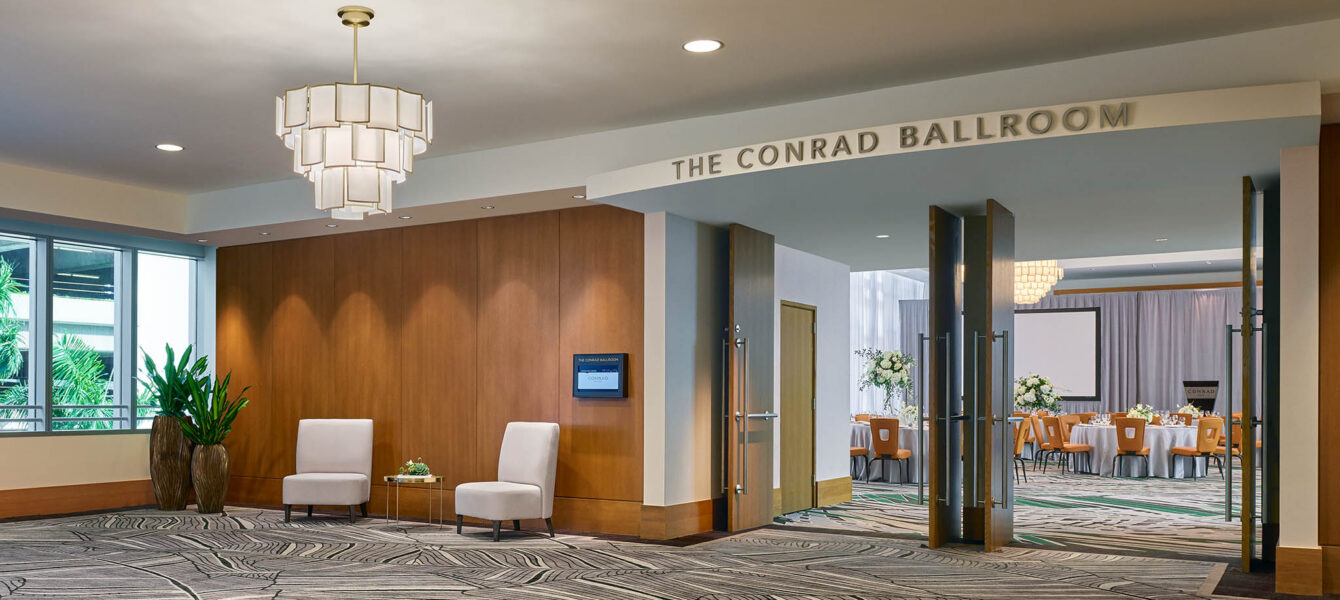 The Conrad Ballroom entrance features a striking leaf-patterned carpet and modern decor, leading to a dining area.